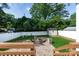 Beautifully landscaped backyard featuring a cozy fire pit area, green turf, and a secure white fence at 2412 Chesterfield Ave, Charlotte, NC 28205