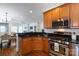 Open concept kitchen with stainless steel appliances, wood cabinets, granite countertops and view into the living room at 2412 Chesterfield Ave, Charlotte, NC 28205