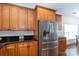 Well-lit kitchen featuring wood cabinets, subway tile backsplash, stainless steel refrigerator, and black granite countertops at 2412 Chesterfield Ave, Charlotte, NC 28205
