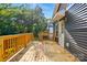 A spacious back deck with wood railing, steps, and a view of home exterior and tree line at 251 Hall Nw Ave, Concord, NC 28027