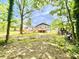 Spacious backyard featuring a deck and a detached garage, surrounded by lush greenery and mature trees at 251 Hall Nw Ave, Concord, NC 28027