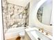 Updated bathroom showcasing a tiled shower-tub combo, modern vanity with round mirror, and updated fixtures at 251 Hall Nw Ave, Concord, NC 28027