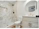 Bright bathroom featuring a marble tiled shower with gold trim, vanity with gold hardware, and round mirror at 251 Hall Nw Ave, Concord, NC 28027