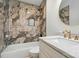 An elegant bathroom offers marble counters, gold fixtures, and a tiled shower/tub combination at 251 Hall Nw Ave, Concord, NC 28027