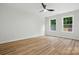 Sunny bedroom features wood floors, a ceiling fan, and large windows with natural light at 251 Hall Nw Ave, Concord, NC 28027