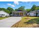 Charming gray home featuring a cozy front porch and an expansive concrete driveway at 251 Hall Nw Ave, Concord, NC 28027