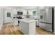 Well-lit kitchen features white cabinetry, stainless appliances, and a convenient island at 251 Hall Nw Ave, Concord, NC 28027