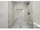 Elegant walk-in shower features marble-patterned tile with black hardware and a recessed shelf for a modern look at 251 Hall Nw Ave, Concord, NC 28027