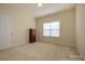 Bedroom with neutral walls and carpet featuring one window and a dark wood dresser at 2598 Old Ashworth Nw Ln, Concord, NC 28027