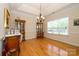 Elegant dining room featuring hardwood floors, classic chandelier, wainscoting and natural light from the large window at 2598 Old Ashworth Nw Ln, Concord, NC 28027