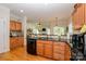 Kitchen with wood cabinets, black countertops, and seamlessly transitions into the living room with a shared breakfast bar at 2598 Old Ashworth Nw Ln, Concord, NC 28027