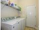 Functional laundry room with washer, dryer, and storage shelf at 2598 Old Ashworth Nw Ln, Concord, NC 28027