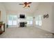 Cozy living room features a fireplace, ceiling fan, and plenty of natural light at 2598 Old Ashworth Nw Ln, Concord, NC 28027