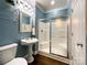 Well-maintained bathroom with a glass-enclosed shower, pedestal sink, tiled floors, and attractive blue walls at 2652 Bedford Nw Pl, Concord, NC 28027