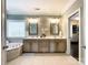 This bathroom has a double vanity with decorative mirrors, a soaking tub, and tile floors at 2652 Bedford Nw Pl, Concord, NC 28027