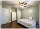 Cozy bedroom featuring hardwood floors, a ceiling fan, and a comfortable bed with decorative patterned bedding at 2652 Bedford Nw Pl, Concord, NC 28027