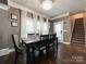 Well-lit dining room featuring a modern chandelier, hardwood floors, and decoratively adorned walls at 2652 Bedford Nw Pl, Concord, NC 28027