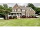 Charming two-story brick home featuring a welcoming front porch and beautifully landscaped front yard with lush green grass at 2652 Bedford Nw Pl, Concord, NC 28027