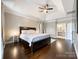 This primary bedroom features a tray ceiling, hardwood floors, and an ensuite bathroom at 2652 Bedford Nw Pl, Concord, NC 28027
