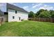 This back yard features a privacy fence, green grass, and mature trees at 3004 Marlowe Ave, Charlotte, NC 28208