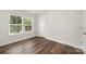 A bright bedroom boasts wood-look flooring, neutral walls, and windows at 3004 Marlowe Ave, Charlotte, NC 28208