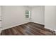 A simple bedroom with wood-look flooring, one window, and neutral walls at 3004 Marlowe Ave, Charlotte, NC 28208