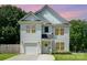 Charming two-story home with white siding, well-manicured lawn and attached garage at dusk at 3004 Marlowe Ave, Charlotte, NC 28208