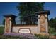 A welcoming Cheval community entrance with stone pillars, iron gate, and colorful flower beds at 3728 Piaffe Ave, Mint Hill, NC 28227