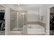 Bright bathroom featuring a tiled shower with glass door and a large soaking tub at 4311 Sheffield Park Ave, Charlotte, NC 28211