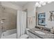 Bathroom featuring a shower with neutral tile, granite vanity, and decorative mirror at 4311 Sheffield Park Ave, Charlotte, NC 28211