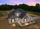 Aerial view of a beautiful home with a well-manicured lawn and a backdrop of lush green trees at sunset at 4949 Rimer Rd # 4, Concord, NC 28025