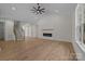 Open floor plan with a living room featuring a vaulted ceiling, modern fireplace and light, wood-look floors at 4975 Rimer Rd # 1, Concord, NC 28025