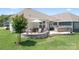 Beautiful backyard featuring a stone patio with a fire pit, outdoor seating, a grill, and lush green grass at 5058 Antebellum Dr, Iron Station, NC 28080