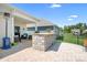 Spacious backyard featuring a patio with an outdoor kitchen, seating area, and lush landscaping at 5058 Antebellum Dr, Iron Station, NC 28080