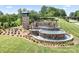 Welcome to The Farm! Stone entrance sign and water feature with lush landscaping at 5058 Antebellum Dr, Iron Station, NC 28080