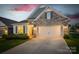Beautiful home exterior illuminated at dusk, showcasing stone accents and a well-maintained driveway at 5058 Antebellum Dr, Iron Station, NC 28080