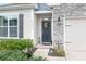 Inviting entryway with a decorative door, stone accents, and lush landscaping enhancing curb appeal at 5058 Antebellum Dr, Iron Station, NC 28080