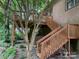 Back exterior showcasing a two-tiered wooden deck with stairs, surrounded by mature landscaping at 5198 Wright Dr, Hickory, NC 28602