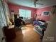 Bright bedroom with pink walls, laminate flooring, a ceiling fan, and a large window allowing for natural light at 5198 Wright Dr, Hickory, NC 28602