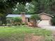 Charming brick home featuring a manicured lawn, a chimney, and a wooden deck at 5198 Wright Dr, Hickory, NC 28602