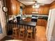 Functional kitchen with wood cabinets, black countertops, and a breakfast bar with stools at 5198 Wright Dr, Hickory, NC 28602