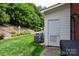 Landscaped backyard featuring a well-manicured lawn, AC unit and a small storage shed against lush greenery at 556 Knighton Hill Rd, Rock Hill, SC 29732