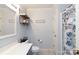 Well-lit bathroom with a large mirror, wooden shelves, and blue and white patterned shower curtain at 556 Knighton Hill Rd, Rock Hill, SC 29732