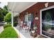 Inviting brick porch with white rocking chairs and charming decor enhances this home's curb appeal at 556 Knighton Hill Rd, Rock Hill, SC 29732