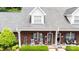 Charming brick home with a cozy front porch featuring rocking chairs and manicured landscaping at 556 Knighton Hill Rd, Rock Hill, SC 29732