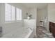 Spa-like bathroom featuring a large soaking tub and window with plantation shutters at 6192 Kilchurn Dr, Fort Mill, SC 29707