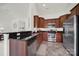 Stylish kitchen featuring stainless steel appliances, dark countertops, and rich wood cabinetry at 6192 Kilchurn Dr, Fort Mill, SC 29707