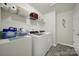 Functional laundry room includes modern washer and dryer with storage shelves at 6192 Kilchurn Dr, Fort Mill, SC 29707