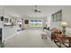 Open-concept living room with neutral carpet, a ceiling fan, and natural light from the backyard view at 6192 Kilchurn Dr, Fort Mill, SC 29707