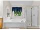 Large soaking tub next to a glass shower and window with natural light at 6300 Latta Springs Cir, Huntersville, NC 28078